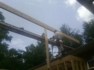 Carpenter setting a ridge beam over a new addition frame — Ice Dam Removal by Roofing Brothers in Stinson Beach